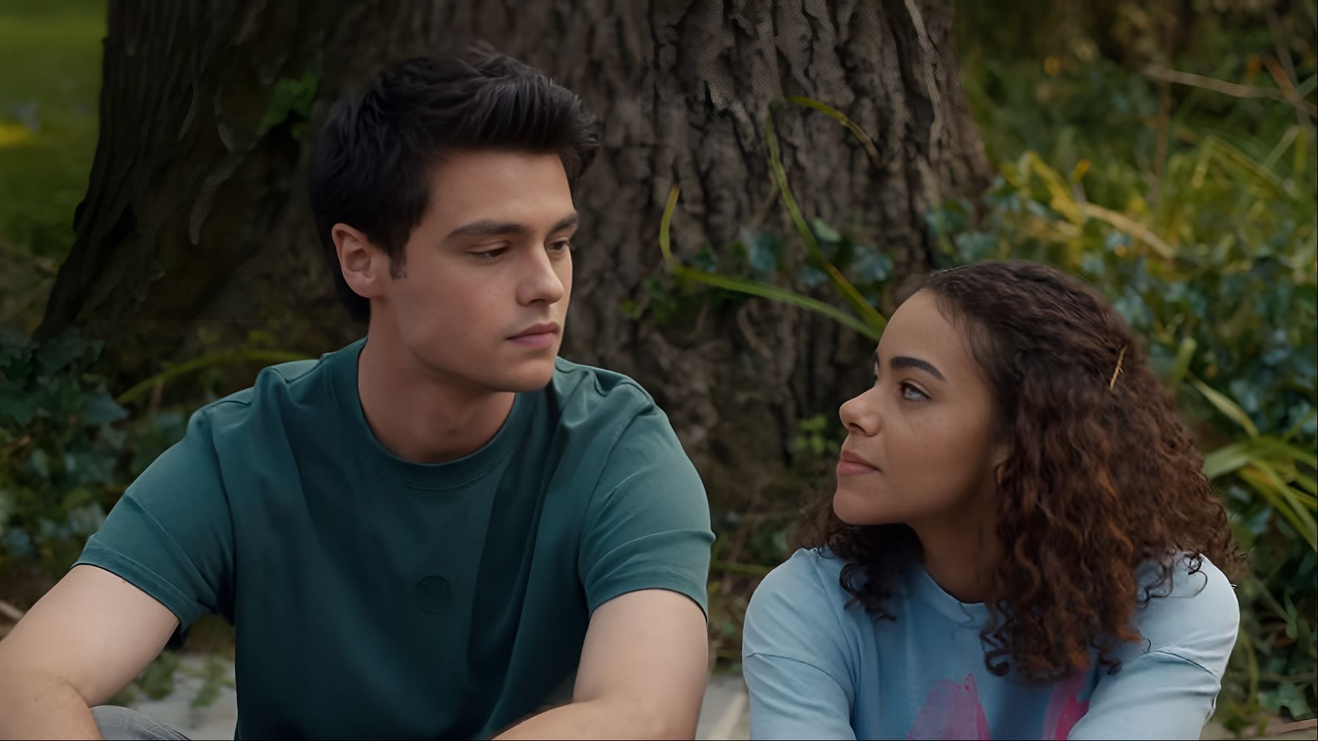 Marcus and Ginny sit beneath a tree in an intimate moment during a quiet scene in Ginny & Georgia season 3, reflecting the emotional weight of their relationship (Image via Netflix)